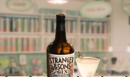 Stranger and Sons gin bottle on wooden table with glass